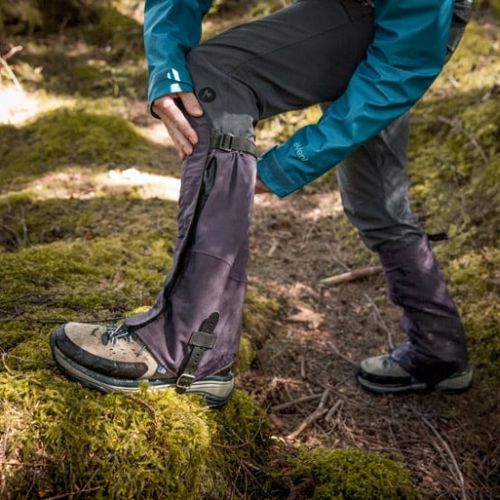 a hiker adjusting their gaiters to fit properly