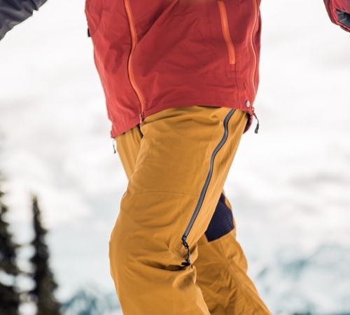 A skier wearing bibs with thigh vents