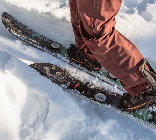 A person skiing on a splitboard in the backcountry