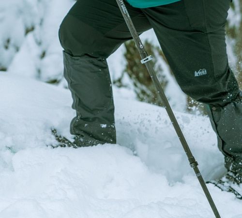 a snowshoer making their way through deep snow with gaiters on